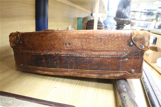 An early 20th century crocodile skin briefcase and a suitcase length 49cm